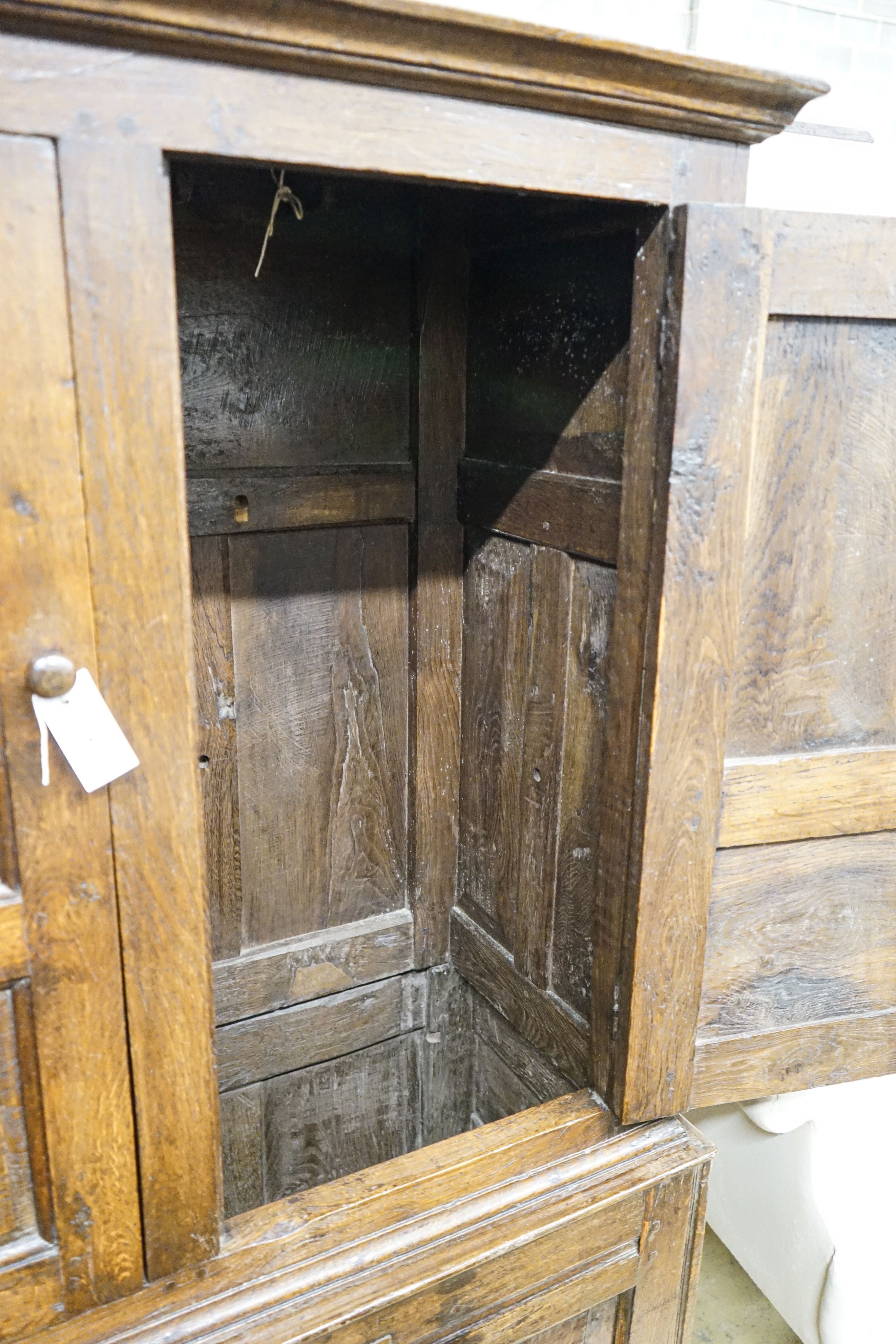 A 17th century style oak press cupboard, with three panelled doors, width 108cm, depth 50cm, height 172cm